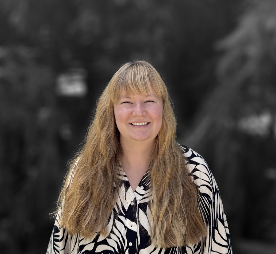 Claire Nyquist smiling in a black-and-white patterned shirt